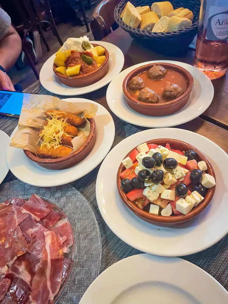 guell tapas restaurant barcelona - abondigas/meatballs, croquettes, patatas bravas, salad, and jamon iberico