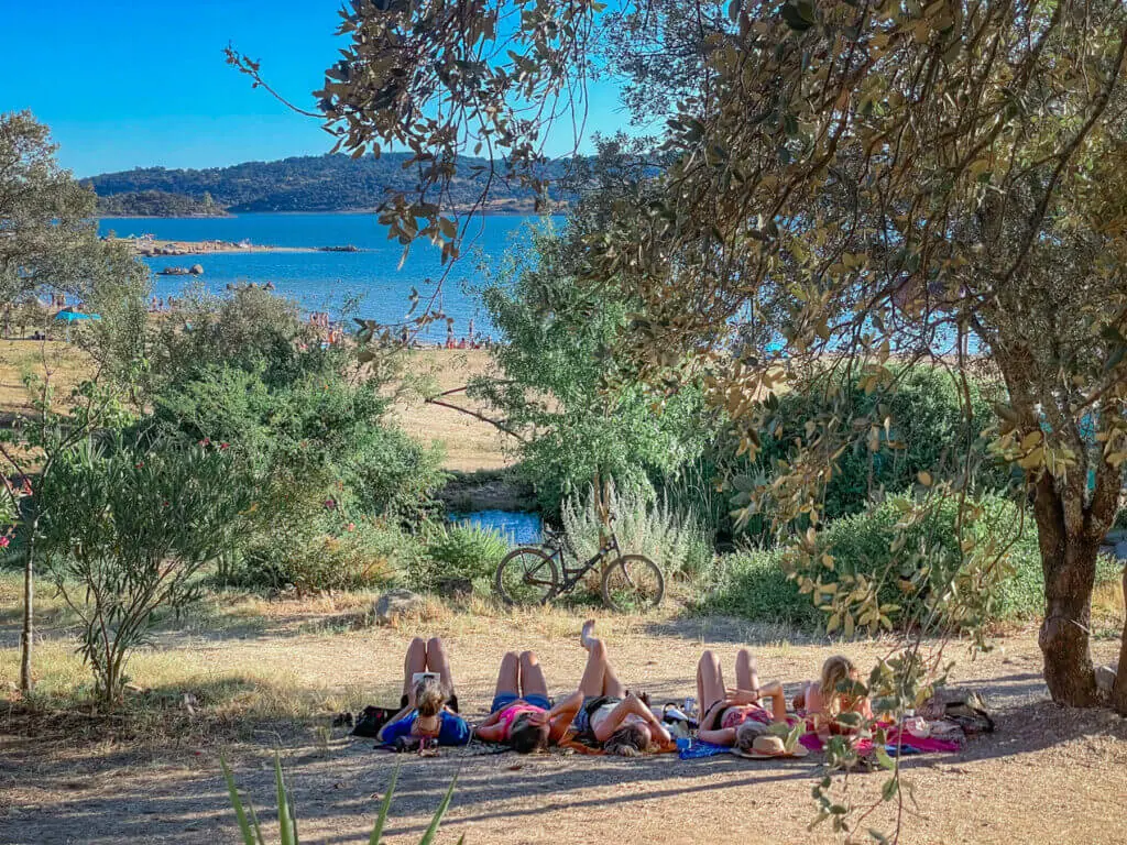 Boom festival relax in the shade group of friends by lake