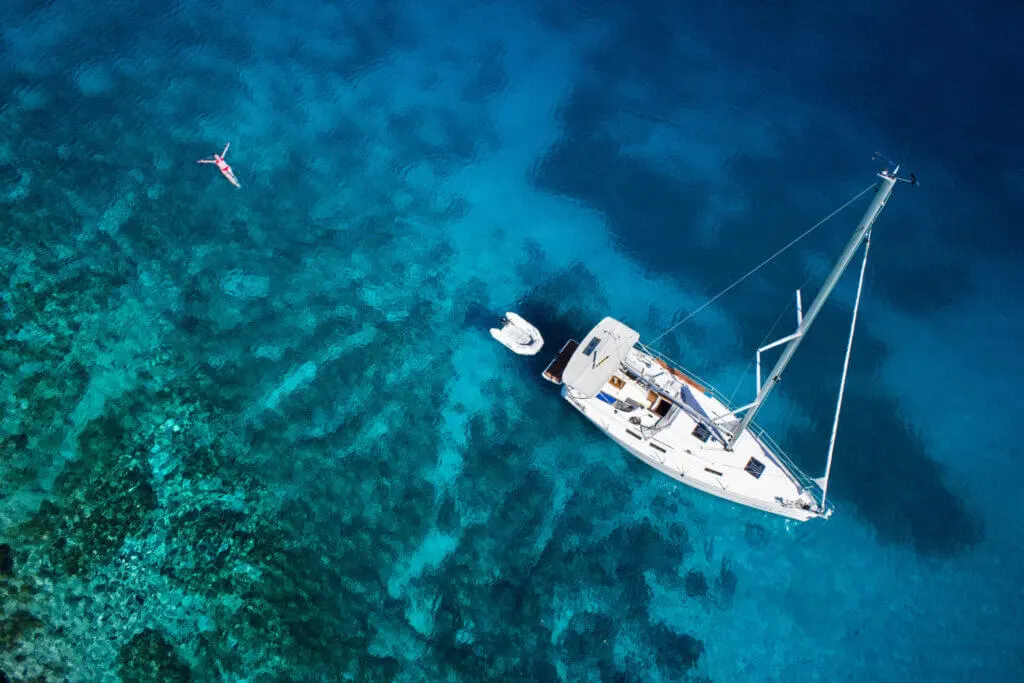 woman swimming in the ocean of a yacht, one of the pros of yacht vs cruise travel