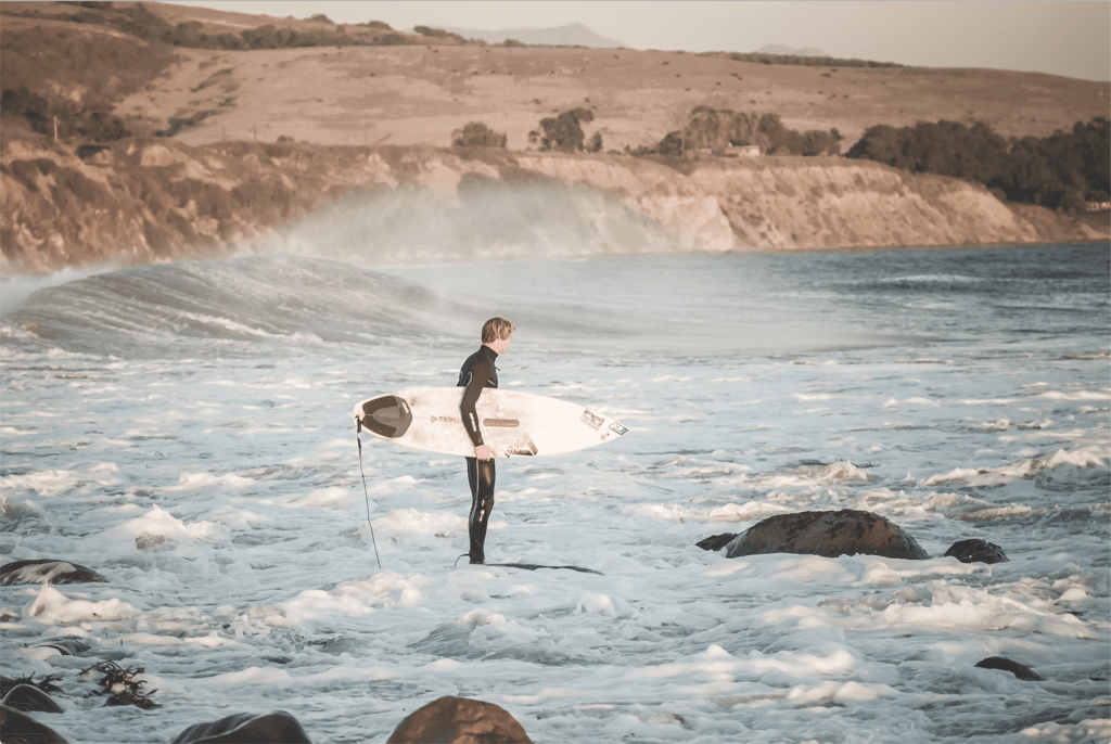 surfer standing at the waves along El Captain trail