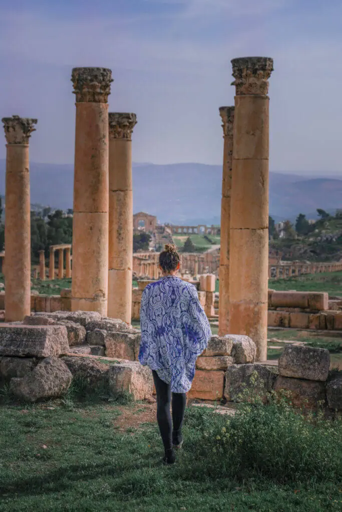 travel blogger at Jerash Jordan looking at hadrian's arch