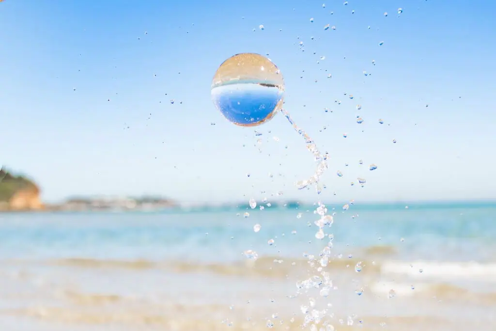 throw glas ball in the air with water beach