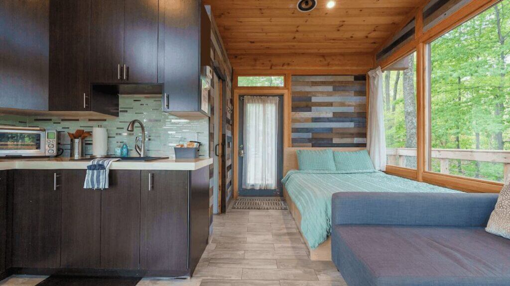 hocking hills treehouse in ohio studio space with bed and kitchen overlooking trees