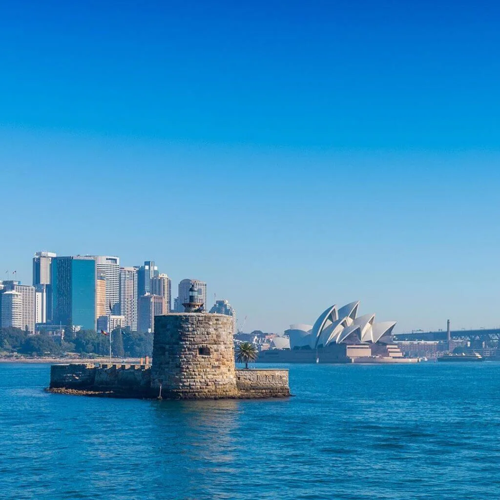 Daylight view of Fort Denison sitting in the middle of Sydney Harbour with the city skyline behind it.