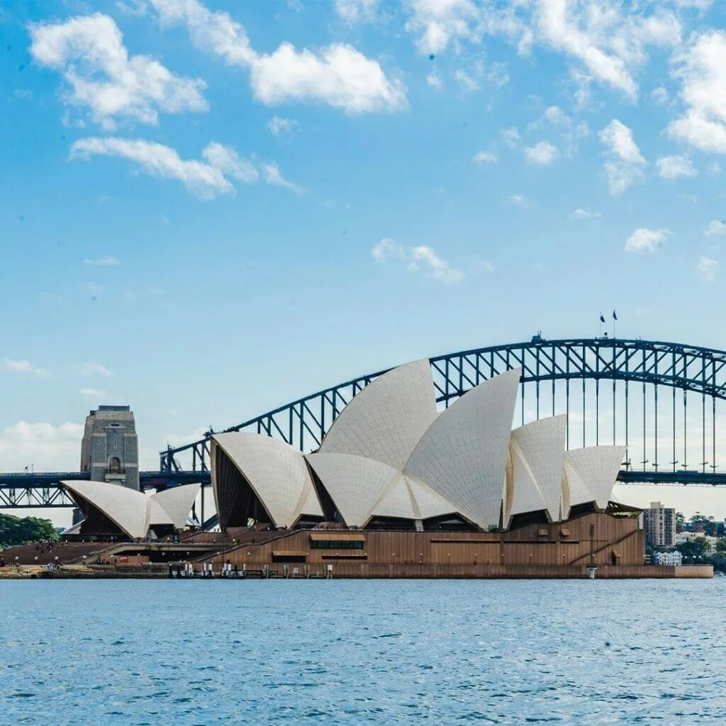Daytime view of the Sydney Opera House from Sydney Harbour showing its iconic sail-shaped architecture.
